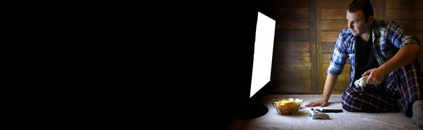 férfi játszik egy konzolon a joystick előtt a nagy TV scree - Fotó, kép