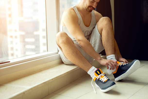 Sportsman putting sneakers on - Photo, Image