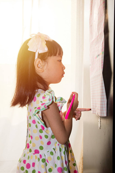Asian Chinese little girl writing on paper with  back lighting - Фото, зображення