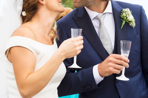 Panna młoda i pan młody trzymający ślubne kieliszki szampana - Zdjęcie, obraz