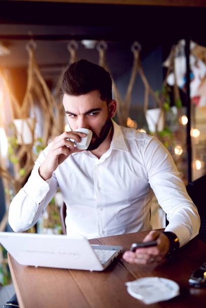 Красивый бизнесмен пьет кофе. - Фото, изображение