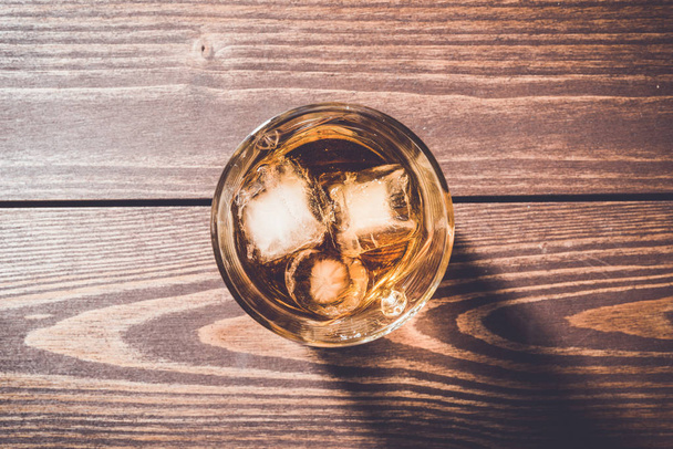 Glass of whiskey on an old wooden table - Foto, Imagen