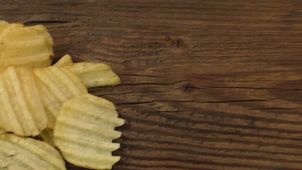 Batatas fritas onduladas em um fundo de madeira
 - Filmagem, Vídeo