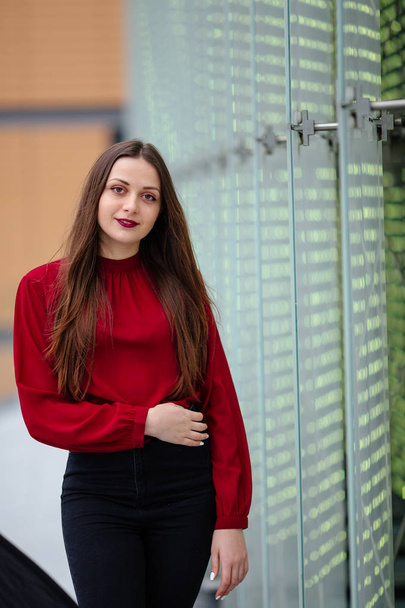 Young business woman standing near wall and smile to camera - Photo, image