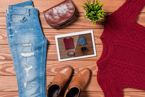 Digital tablet and autumn clothes on wooden table. Online shopping concept - Foto, afbeelding