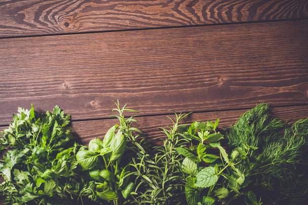 Fresh herbs on an old wooden table - Foto, afbeelding