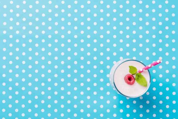 Fresh homemade raspberry smoothie on blue dotted background - Fotoğraf, Görsel
