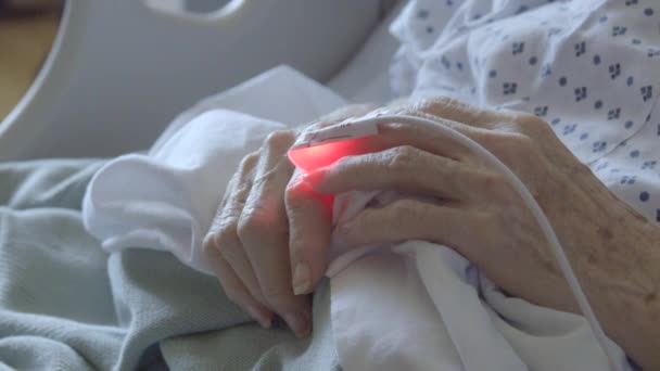 Detail van hartmonitor aangesloten op bejaarde dames vinger - Video