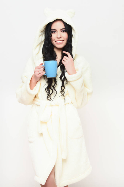 smiling sexy girl posing in beige velour bathrobe with cup - Zdjęcie, obraz