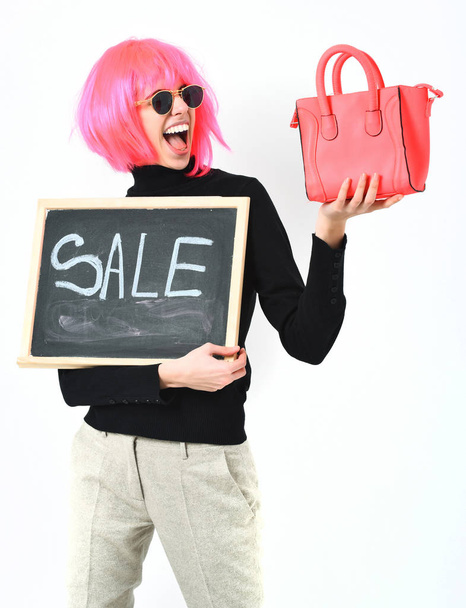 girl in wig holding bag and board with sale inscription - Foto, imagen