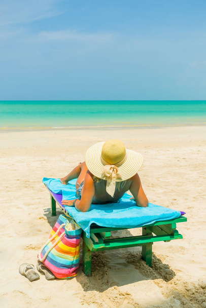 Woman sitting on a chair at the beach - Fotoğraf, Görsel