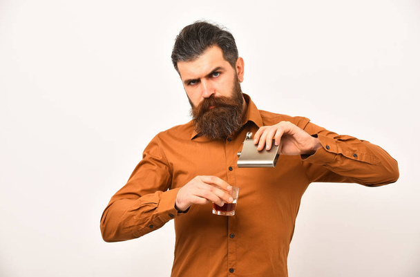 bearded man hipster with metallic jar, glass in orange shirt - Φωτογραφία, εικόνα