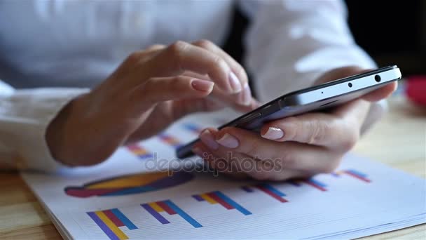 Podnikatelka spolupracuje s mobilním telefonem a burzovní graf. Obchodní hospodářské koncepce - Záběry, video