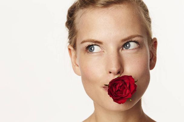 Woman holding rose in mouth - Photo, Image