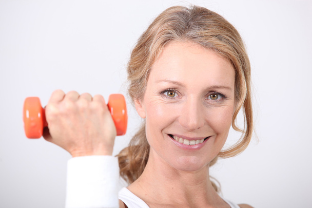 Portrait of a woman with dumbbell - Photo, image