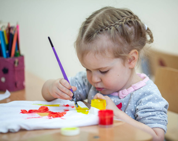 pretty little girl draws with paints, indoor - Φωτογραφία, εικόνα
