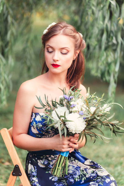 beautiful young woman with a bouquet of flowers in their hands - Φωτογραφία, εικόνα