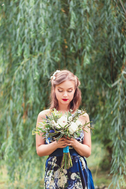 gyönyörű fiatal nő, egy csokor virággal a kezükben - Fotó, kép