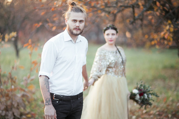 bride couple at autumn park - Foto, afbeelding