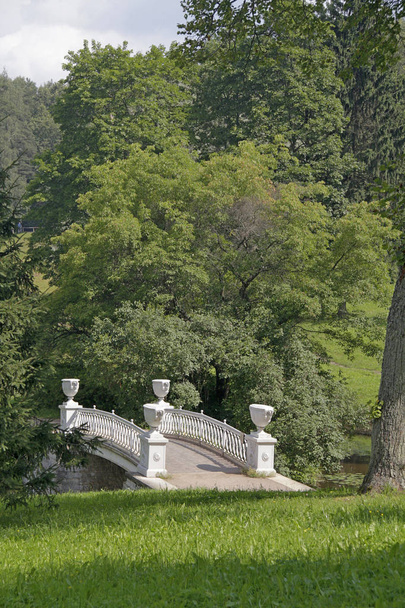 Sommerblick auf die weiße Brücke über den Bach im Park - Foto, Bild