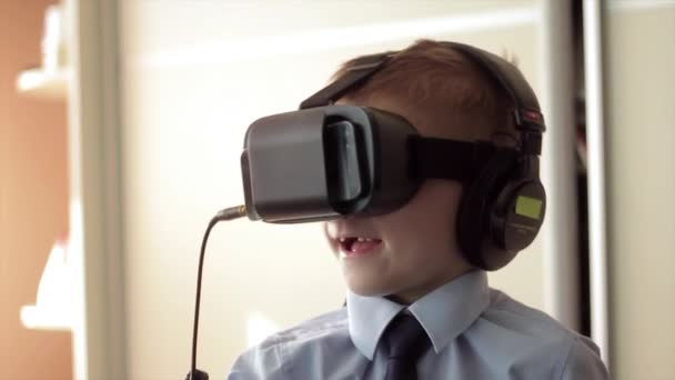 Mały chłopiec wykorzystanie wirtualnej rzeczywistości słuchawki na głowę hełm, on bardzo pod wrażeniem - Materiał filmowy, wideo