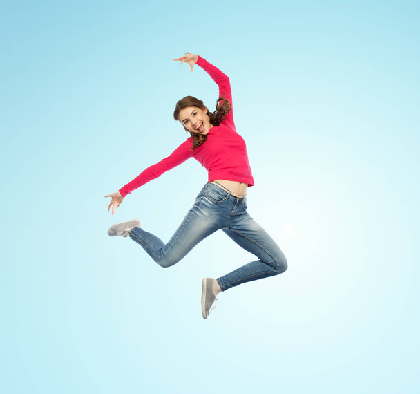 happy young woman jumping in air or dancing - Foto, afbeelding