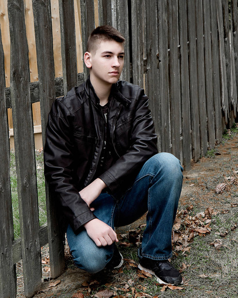 High School férfi ül a fából készült kerítés a fekete bőr Juhász Gábor - Fotó, kép
