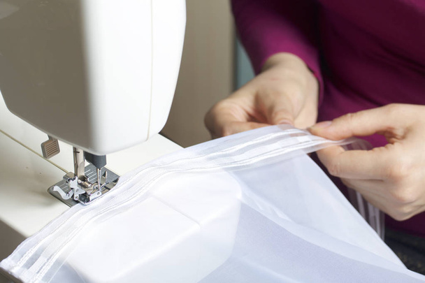 A woman works on a sewing machine. - Photo, image