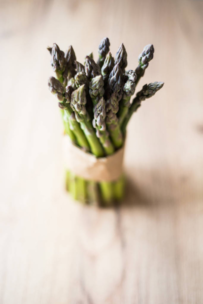 Asparagus bunch close up on wooden background - Fotoğraf, Görsel