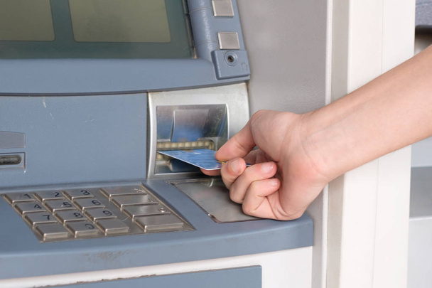 Мужская рука вставляет кредитную карту в банкомат
 - Фото, изображение