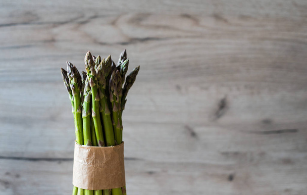 Asparagus bunch close up on wooden background - 写真・画像