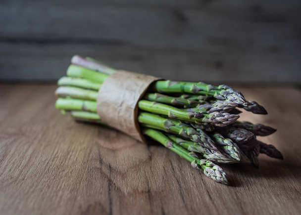 Asparagus bunch close up on wooden background - Fotó, kép