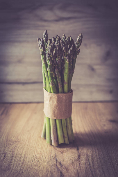 Asparagus bunch close up on wooden background - Фото, изображение
