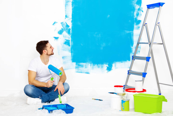 Riparazione in appartamento. Uomo felice dipinge muro
  - Foto, immagini