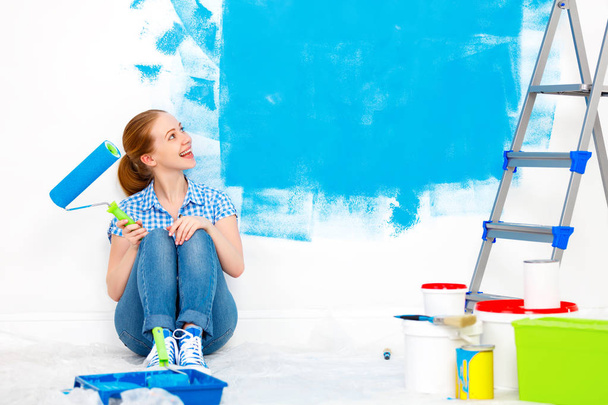 Επισκευή σε διαμέρισμα. Ευτυχισμένη γυναίκα χρώματα τοίχου  - Φωτογραφία, εικόνα