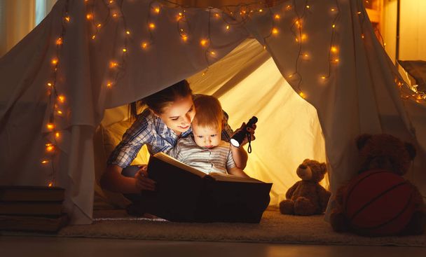 mother and child daughter with a book and a flashlight before go - Foto, Bild