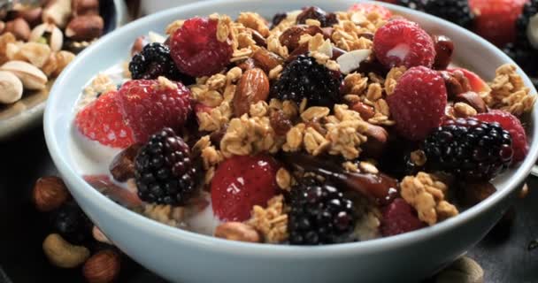 A breakfast of cereals with berries, dry fruits and milk - Footage, Video