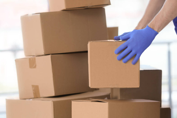 Delivery man moving boxes indoors - Fotó, kép