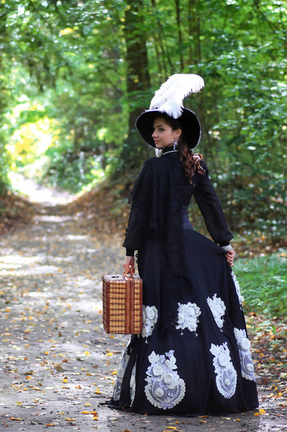 chica en vestido retro del siglo 18 con valise en el parque
 - Foto, Imagen