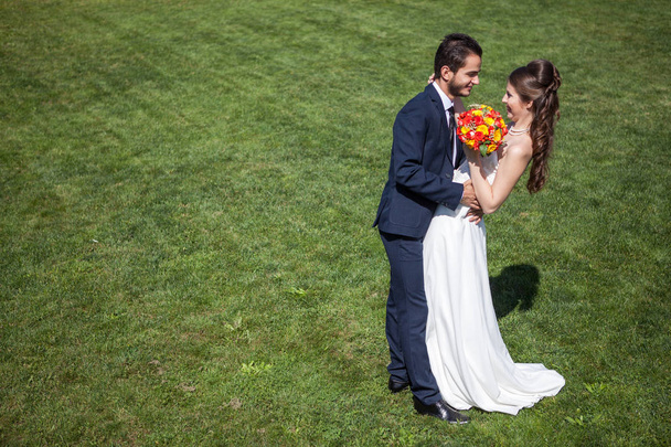 Щаслива дружина і наречений на трав'яному полі в сонячний літній день
 - Фото, зображення