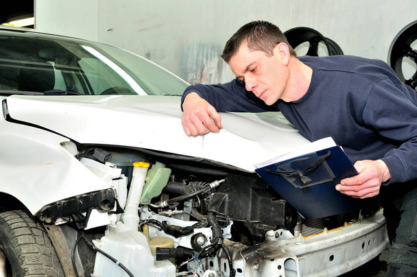 Monteur inspecteren auto lichaam schade bij auto reparatie winkel  - Foto, afbeelding