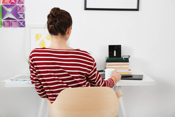 Woman sitting at workplace - Фото, изображение