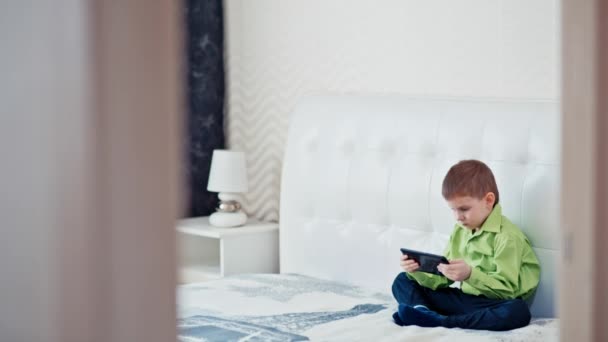 A boy plays on the tablet. Slow motion - Záběry, video