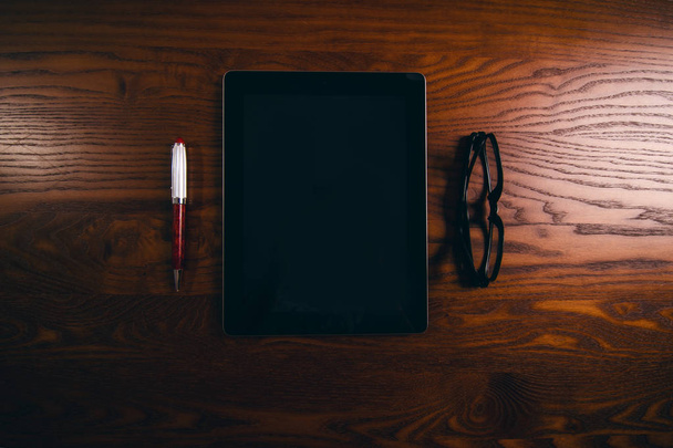 Celular, tablet, laptop con gafas y bolígrafo. Mesa de madera natural. Antecedentes. Concepto de tecnología
 - Foto, Imagen