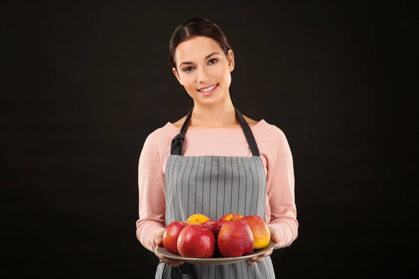 Young woman holding plate with apples - Foto, imagen