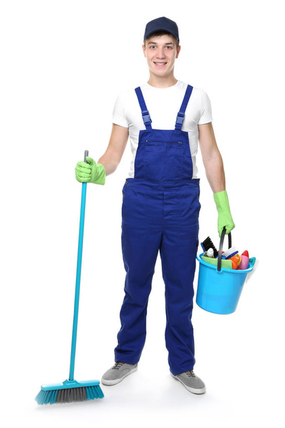 Young man holding cleaning equipment and supplies on white background - Foto, Imagen