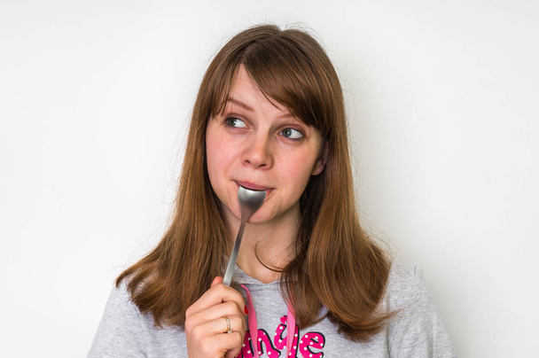 Young beautiful woman with spoon in mouth - Foto, Imagem