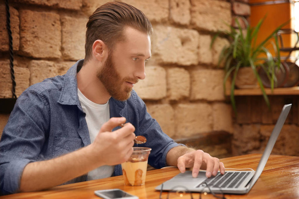 Handsome young man with laptop - Фото, изображение