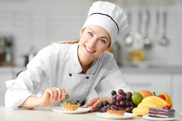 Жіночий шеф-кухар прикрашає тартлет
 - Фото, зображення