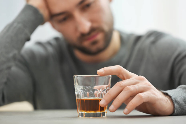Hombre solitario y deprimido bebiendo whisky en casa, primer plano
 - Foto, Imagen